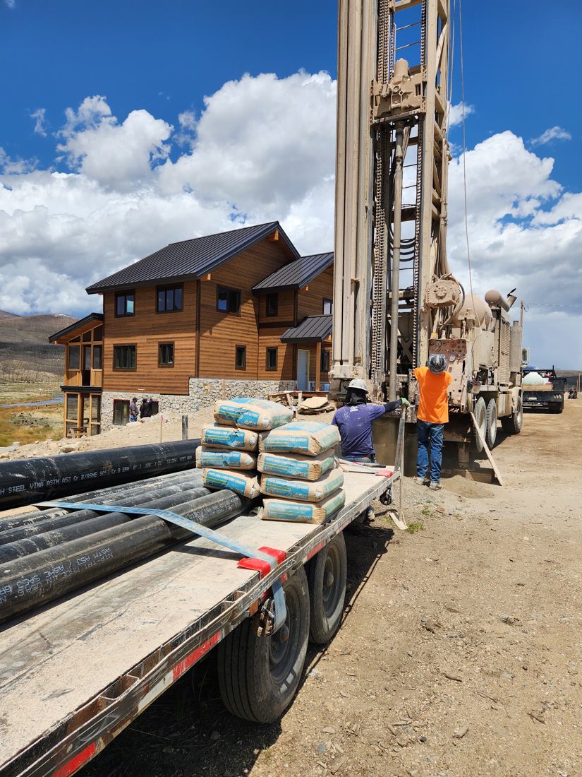 Holland & Sons drill rig set up beside a new mountain home