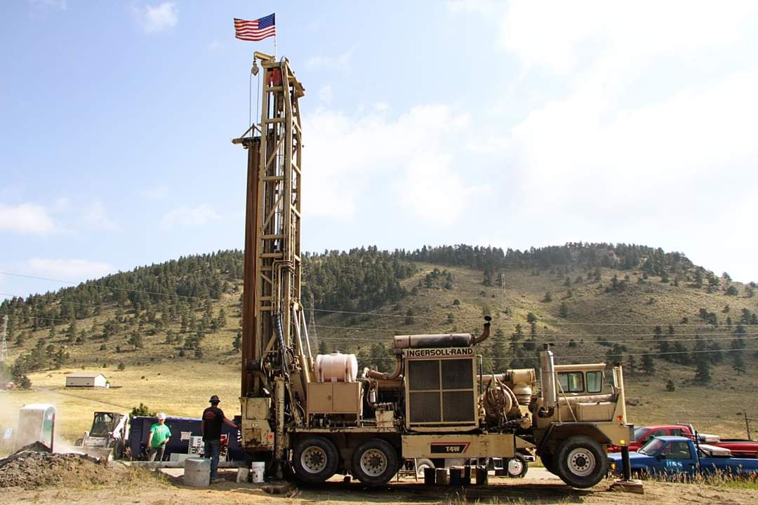 Holland & Sons drill rig under an American flag